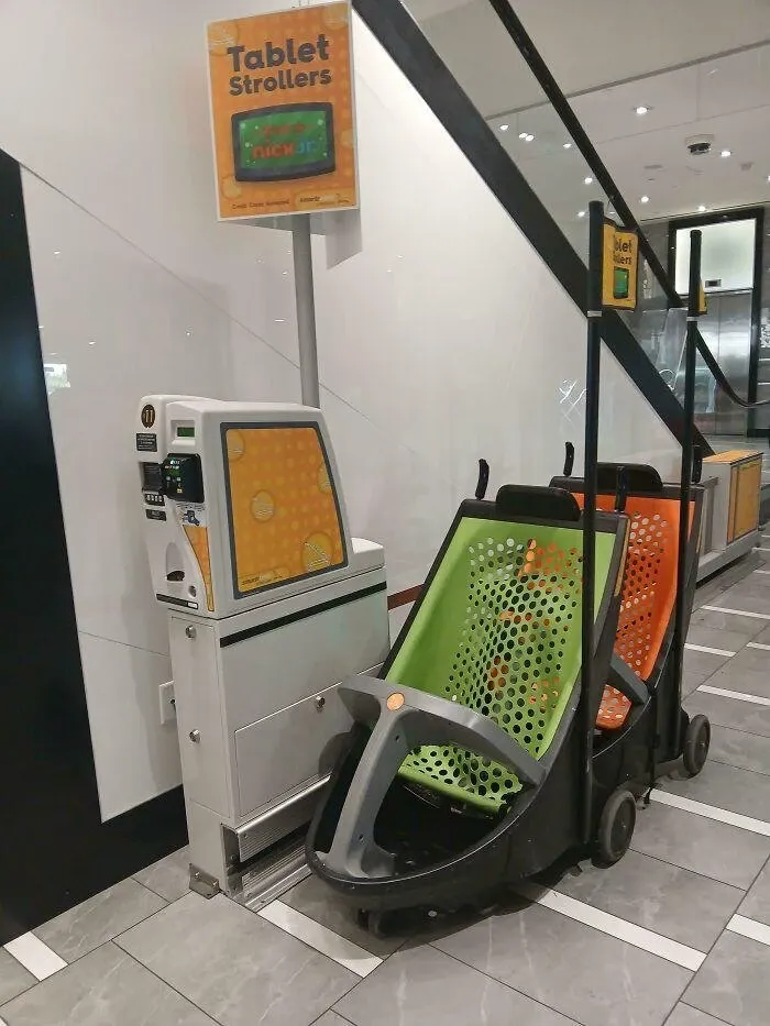 A mall kiosk renting "Tablet Strollers": a row of strollers with a Nick Jr. tablet built into each one, credit cards accepted